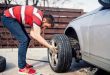 Hombre monta una rueda de repuesto en su coche