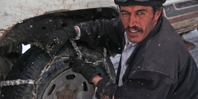 mecanico intentando poner las cadenas de nieve