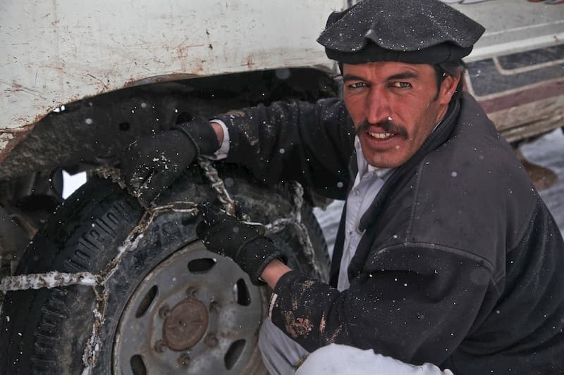 mecanico intentando poner las cadenas de nieve