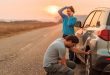 Couple repairing car flat tire on the road