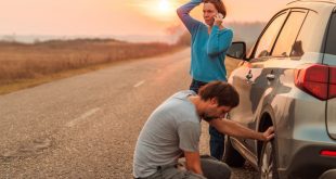 Couple repairing car flat tire on the road