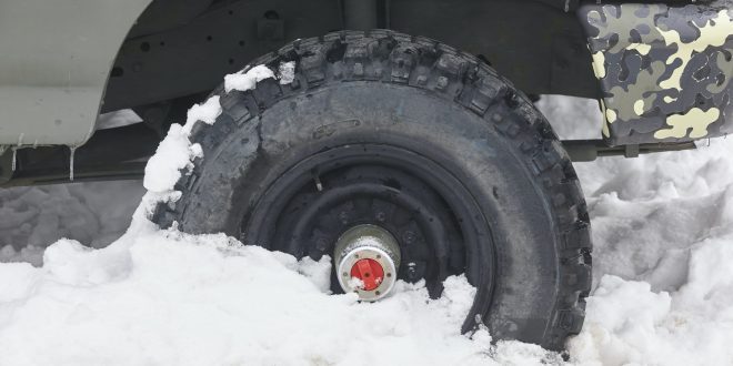 Four wheel vehicle tyre trapped on the snow. Winter time