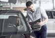 An African man who buys a new car checks a car talking to a professional vendor