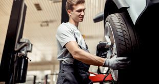 An automechanic changes a tire while at work at a car repair service