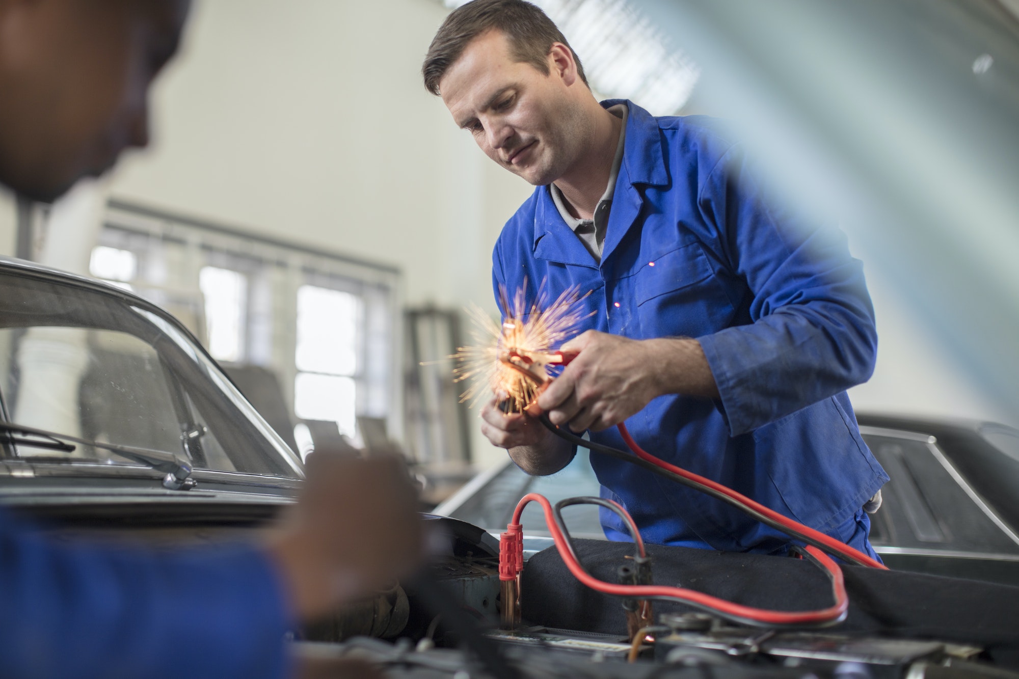 Car mechanics testing car engine in repair garage