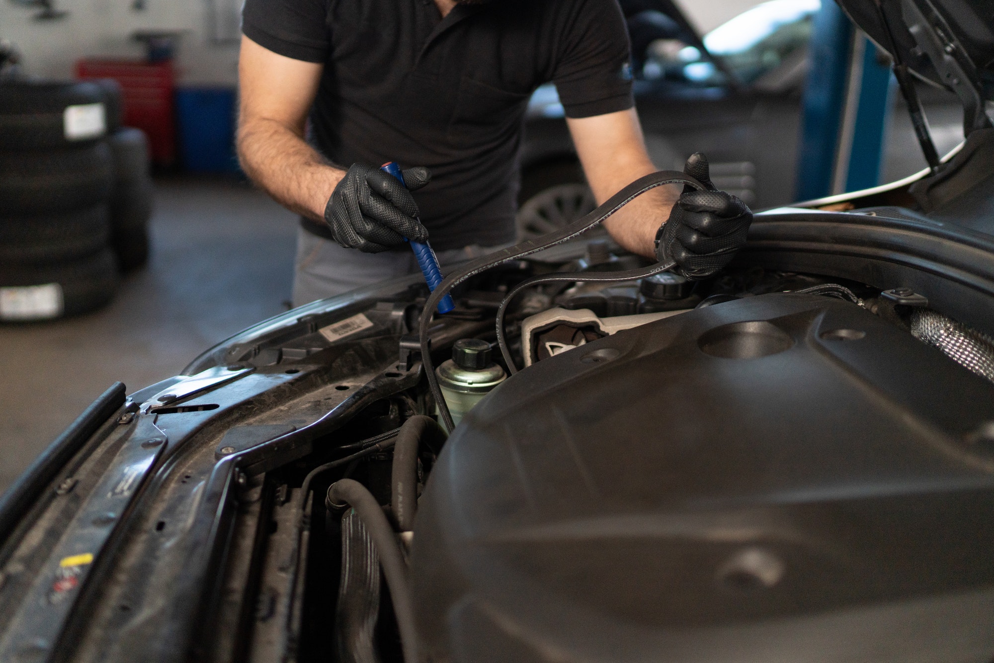 Car service technician changes timing belt of car