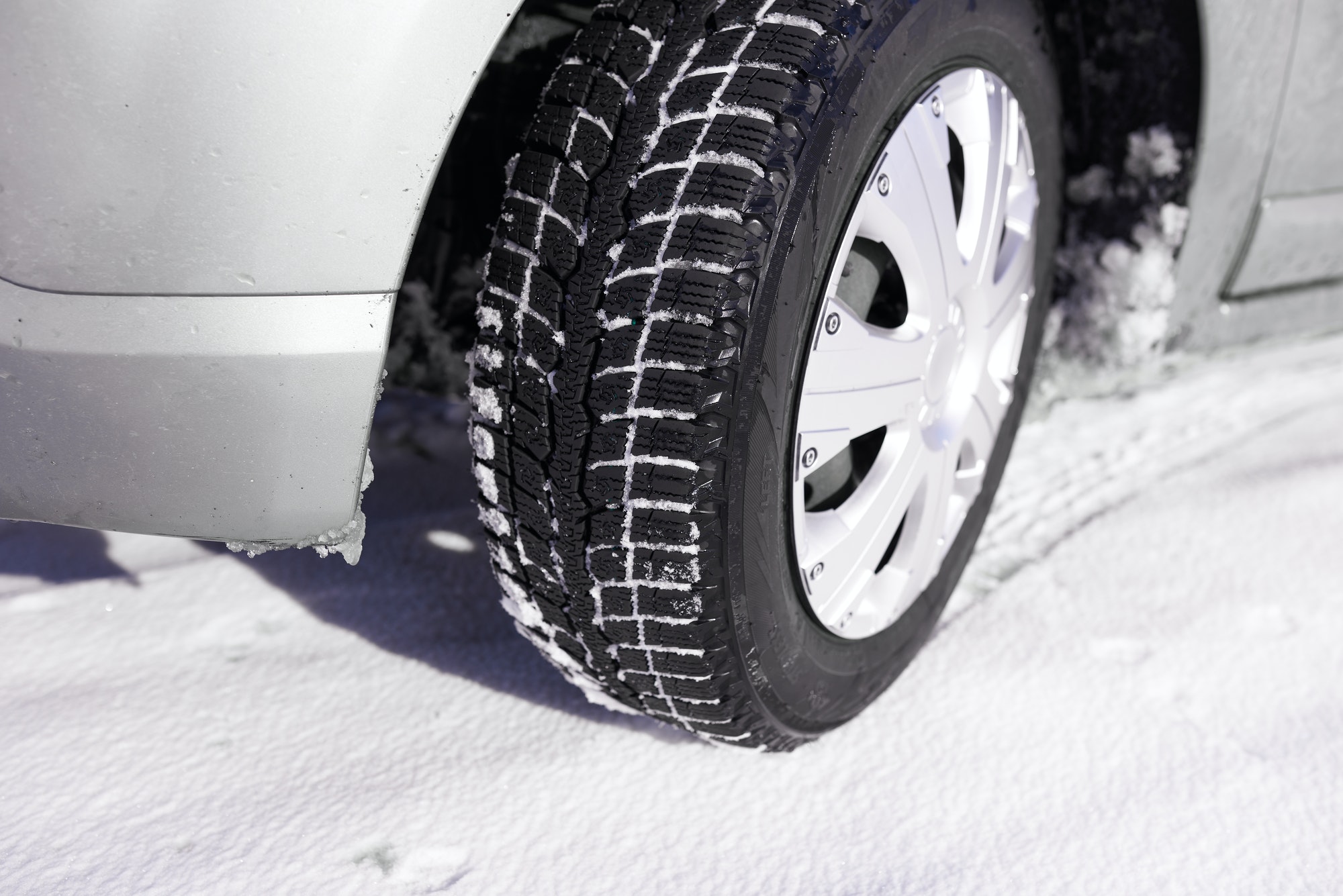 Car tires on winter snow road