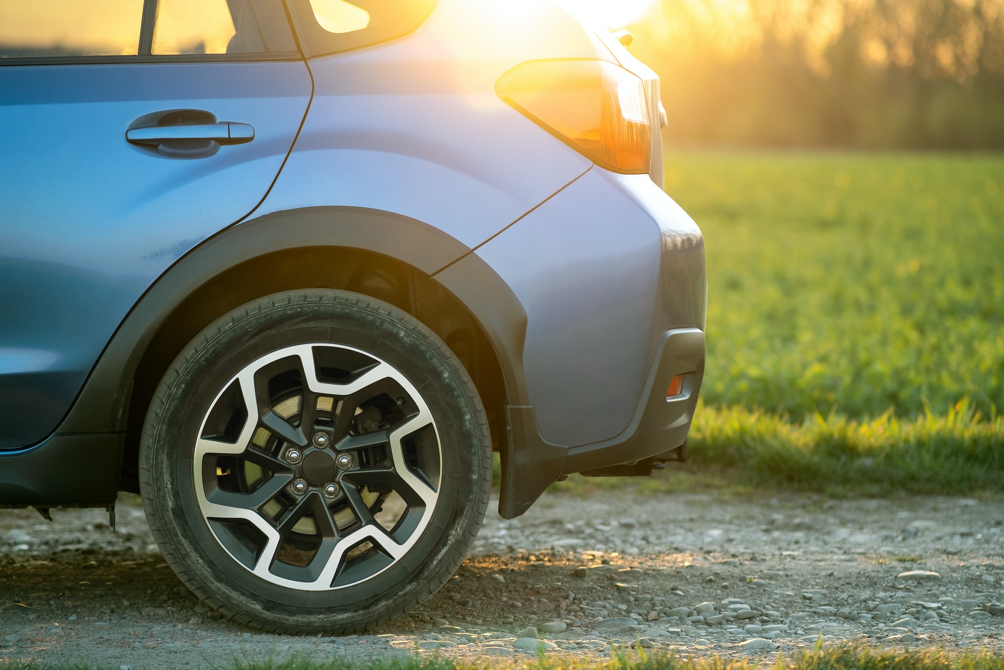 Close up of blue off road car wheel on gravel road. Traveling by auto, adventure in wildlife