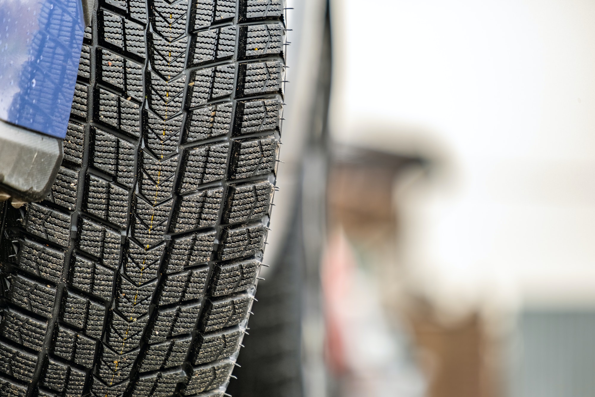 Closeup of parked car on a city street side with new winter rubber tires