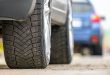 Closeup of parked car on a city street side with new winter rubber tires
