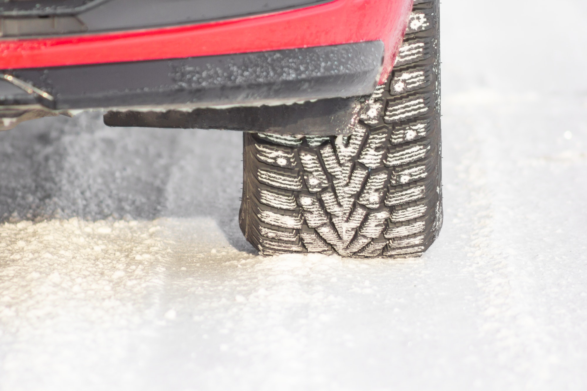 Detail of a tire on a winter road. Safe car driving concept.
