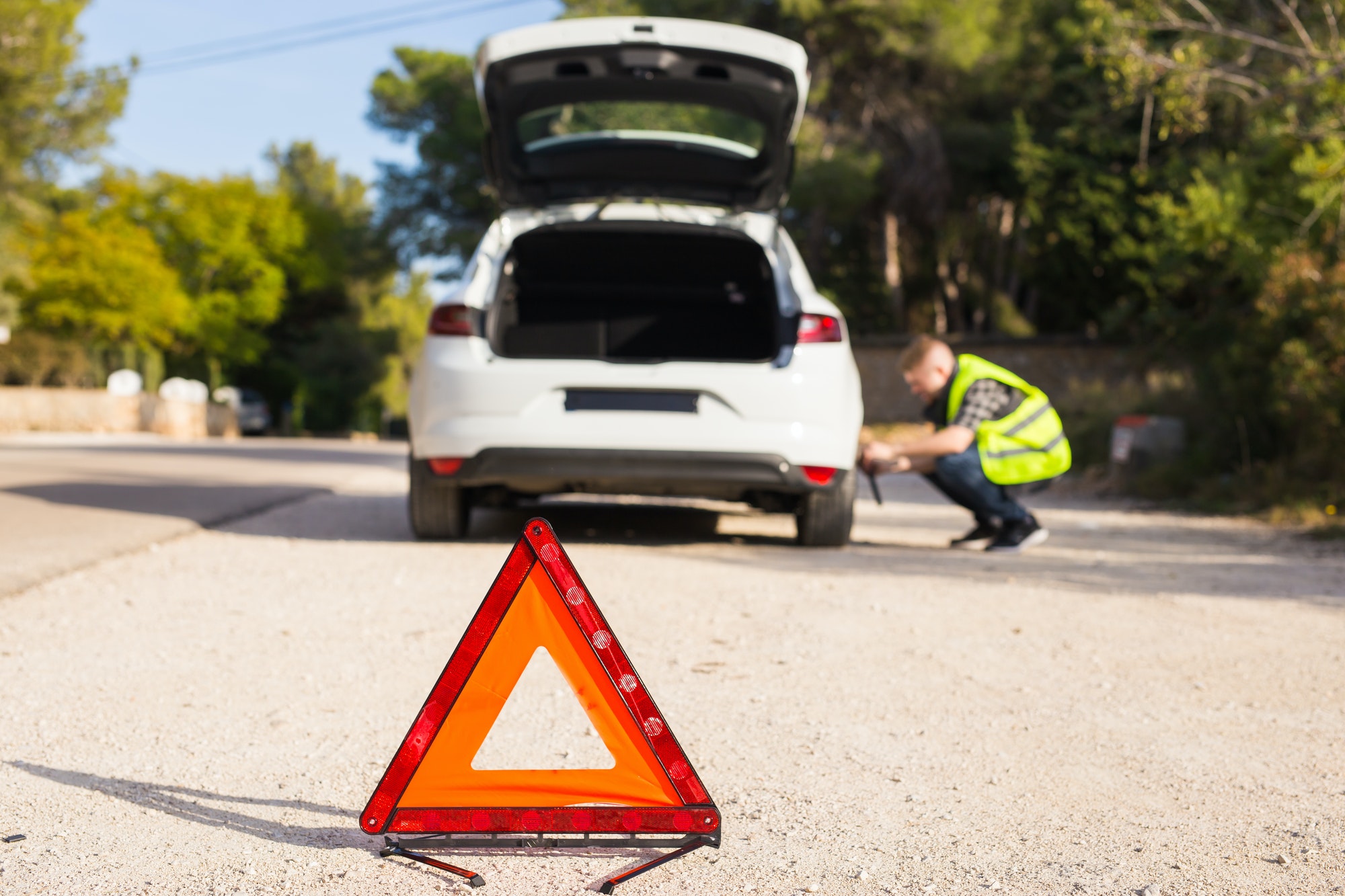 Emergency sign on the background of the car and the man