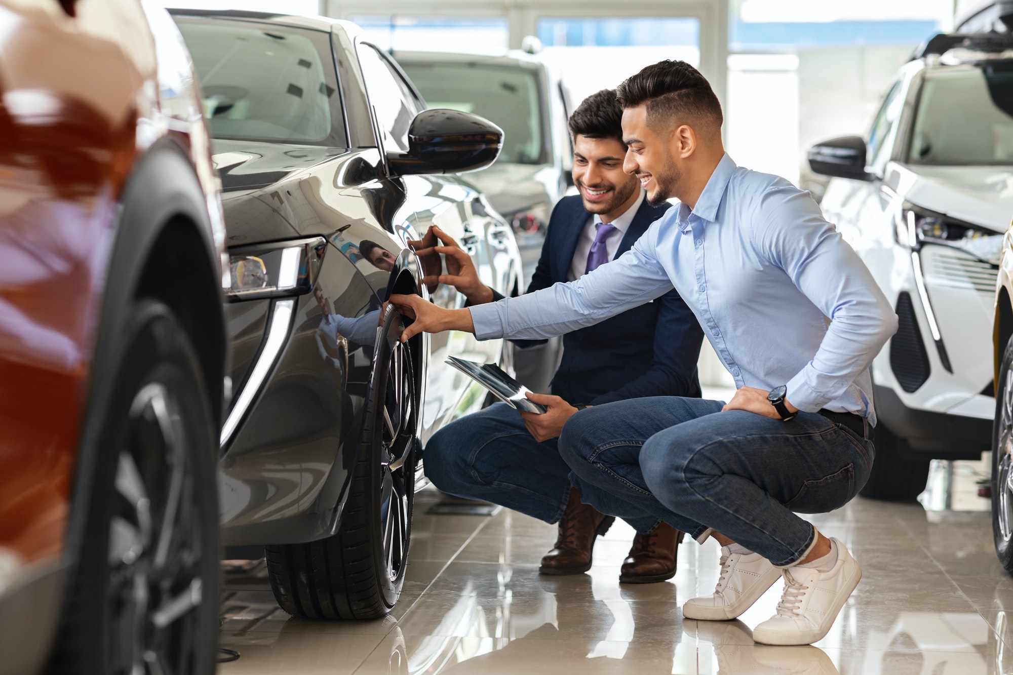 Handsome arab guy customer choosing new sports car