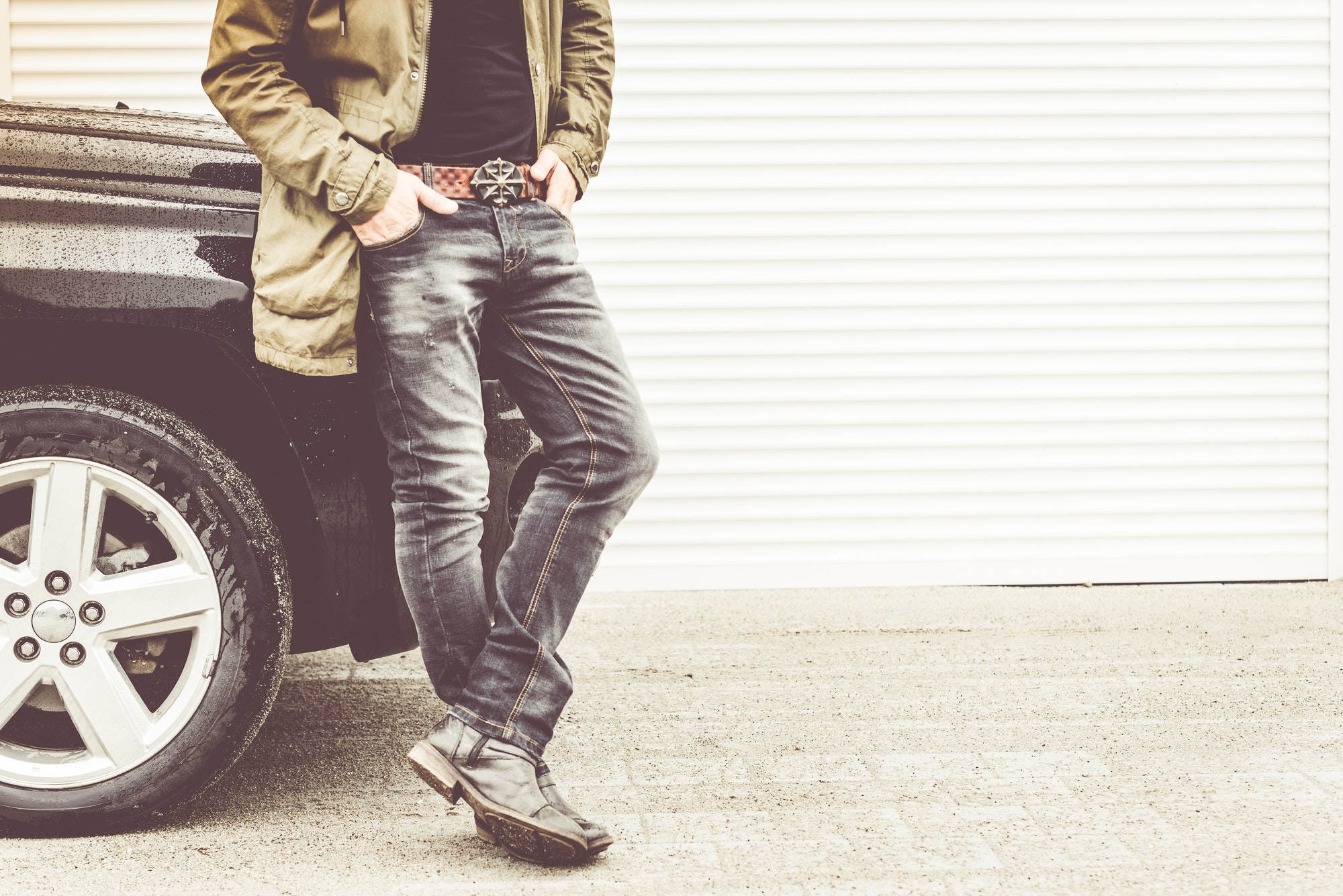 Handsome young man standing next to off road 4x4 car