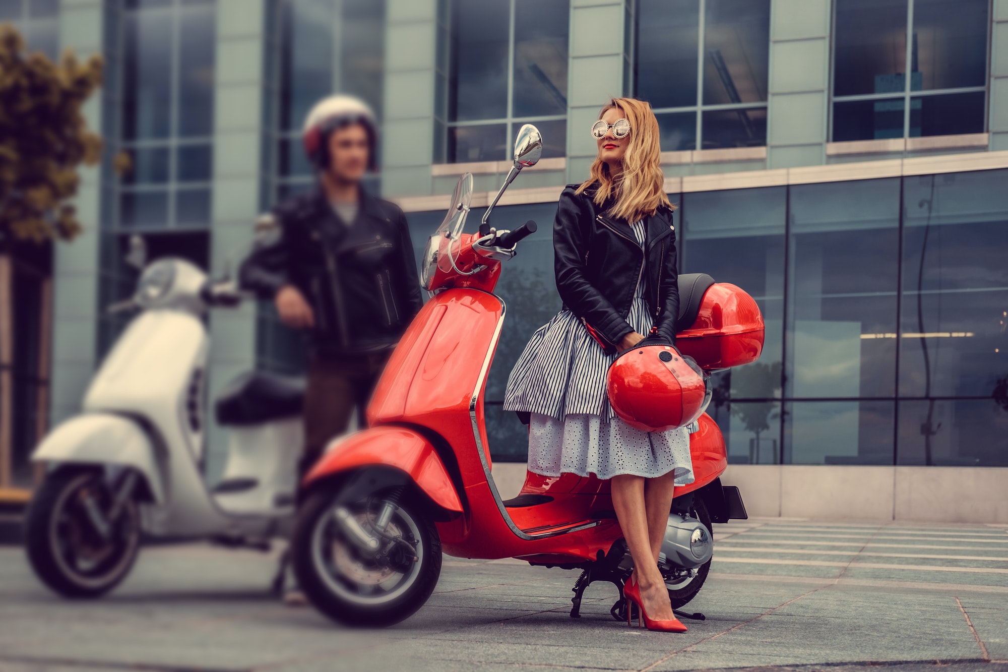 Male and female having fun on moto scooters.