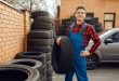 Male worker at the stack of tyres, tire service