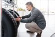 Man choosing tyres for new car in showroom