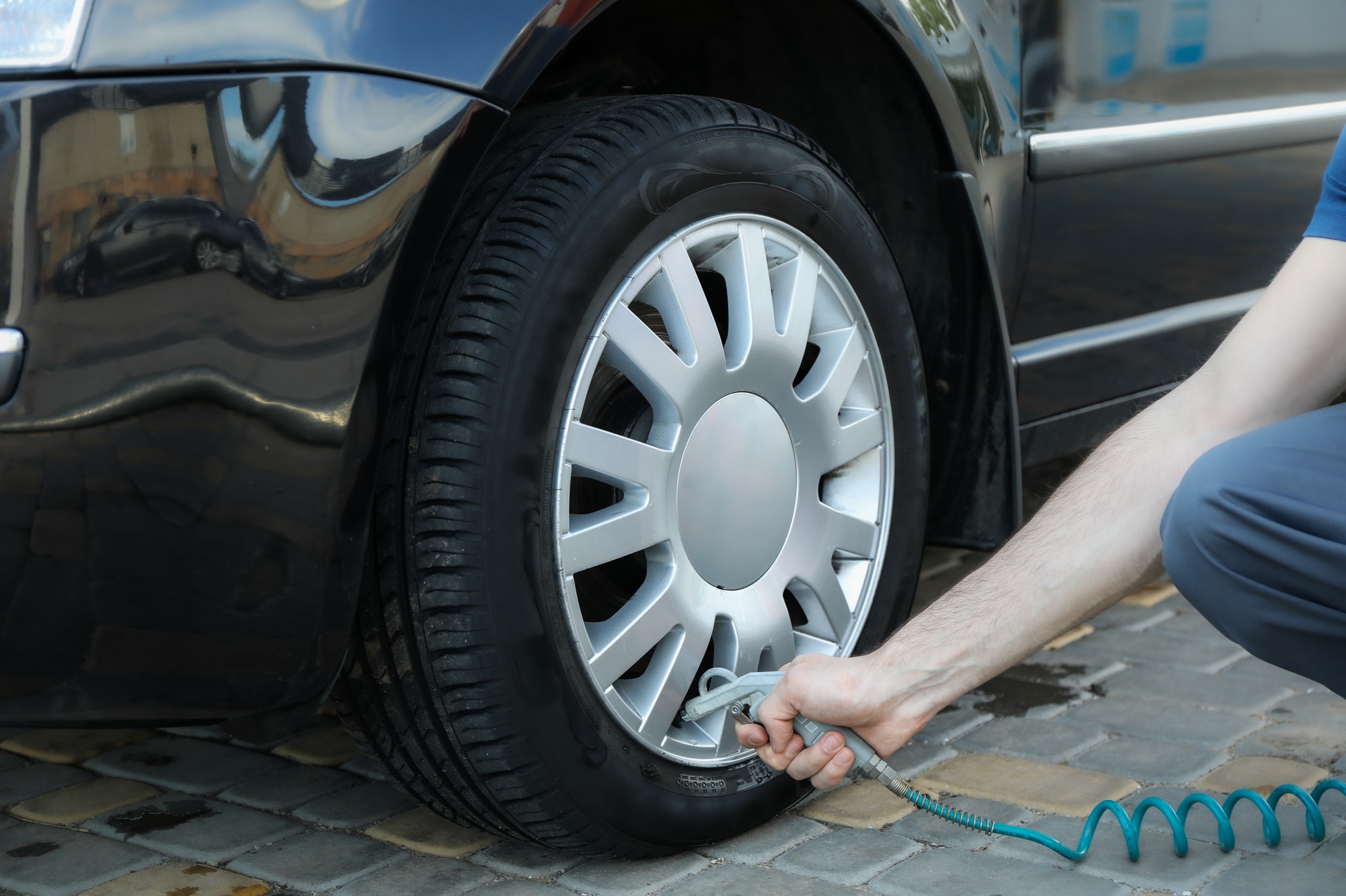 Man pumps up tires. Car inspection. Maintenance