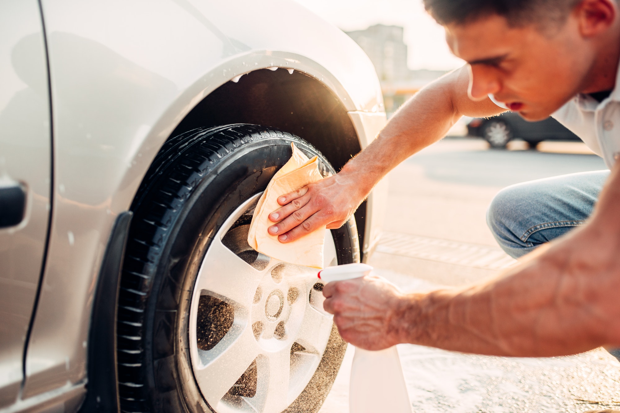 Man with car rims cleaner, carwash