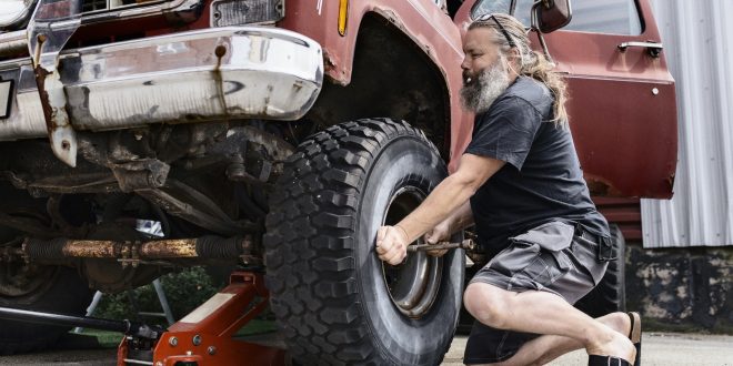 Mature man repairing old car