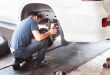 Mechanic inspecting the suspension and brakes of car at workshop