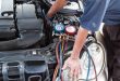 Mechanic with manometer inspecting auto vehicle air-condition co