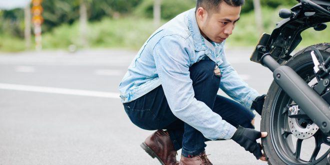 Motorcyclist taking off tire