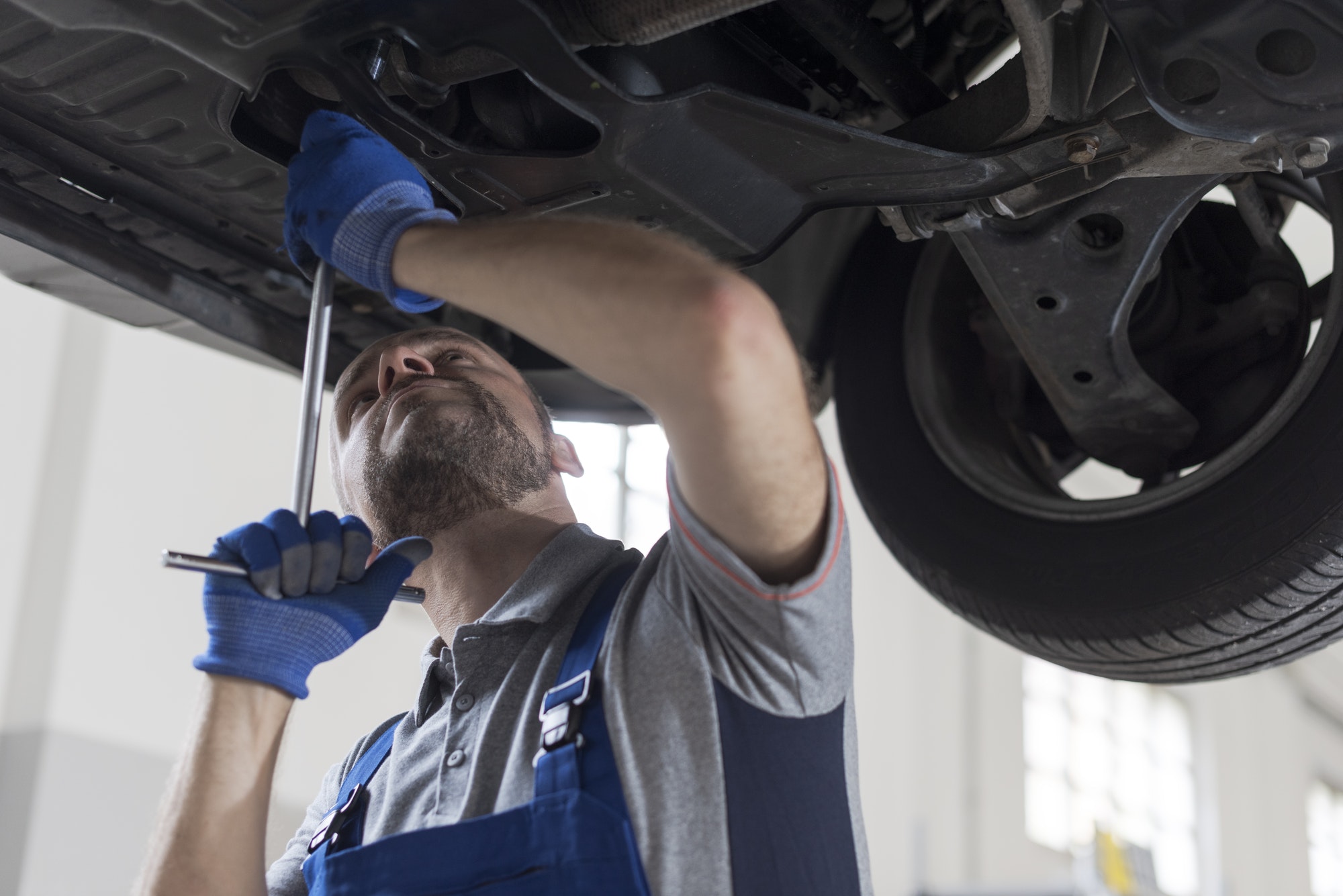 Professional mechanic working under a car