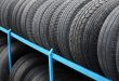 Rack with variety of car tires in automobile store. Many black tires. Tire stack background