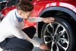 Salesman checking the shiny rims in new car