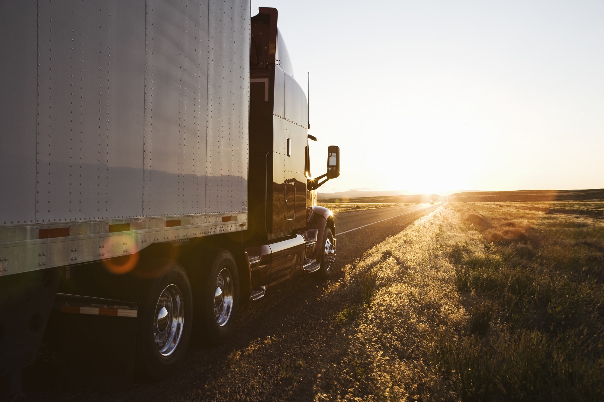 Side view of a trailer and truck on the road at sunset in eastern Washington, USA