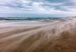 Stormy sea, wind blowing sand on the beach