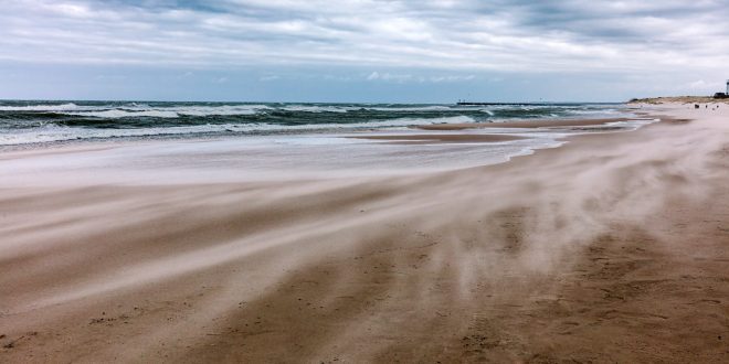 Stormy sea, wind blowing sand on the beach