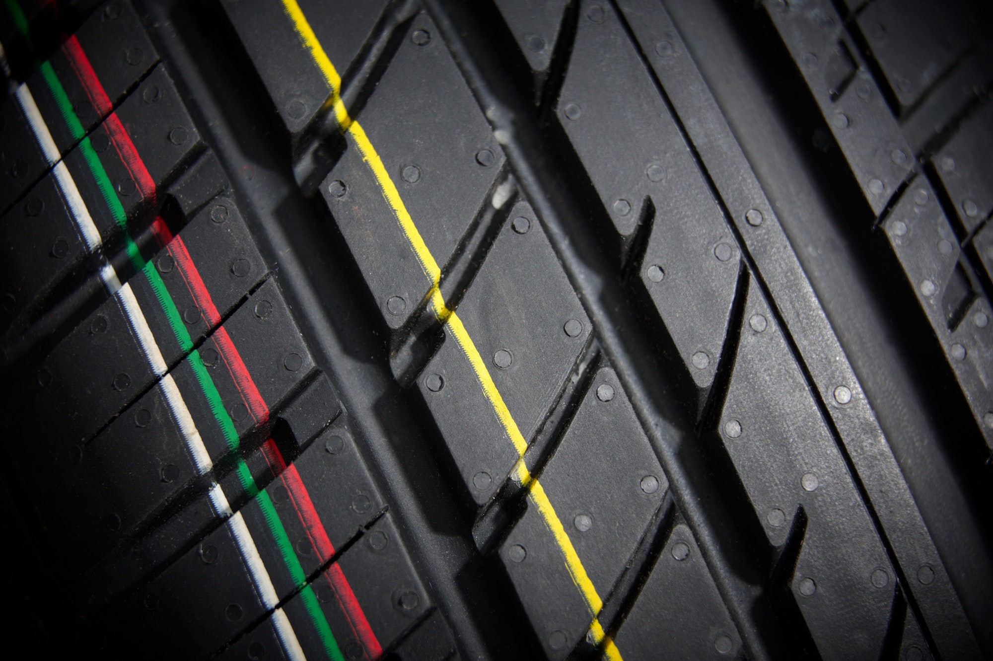 Studio shot of a set of summer car tires on black background. Contrasty lighting
