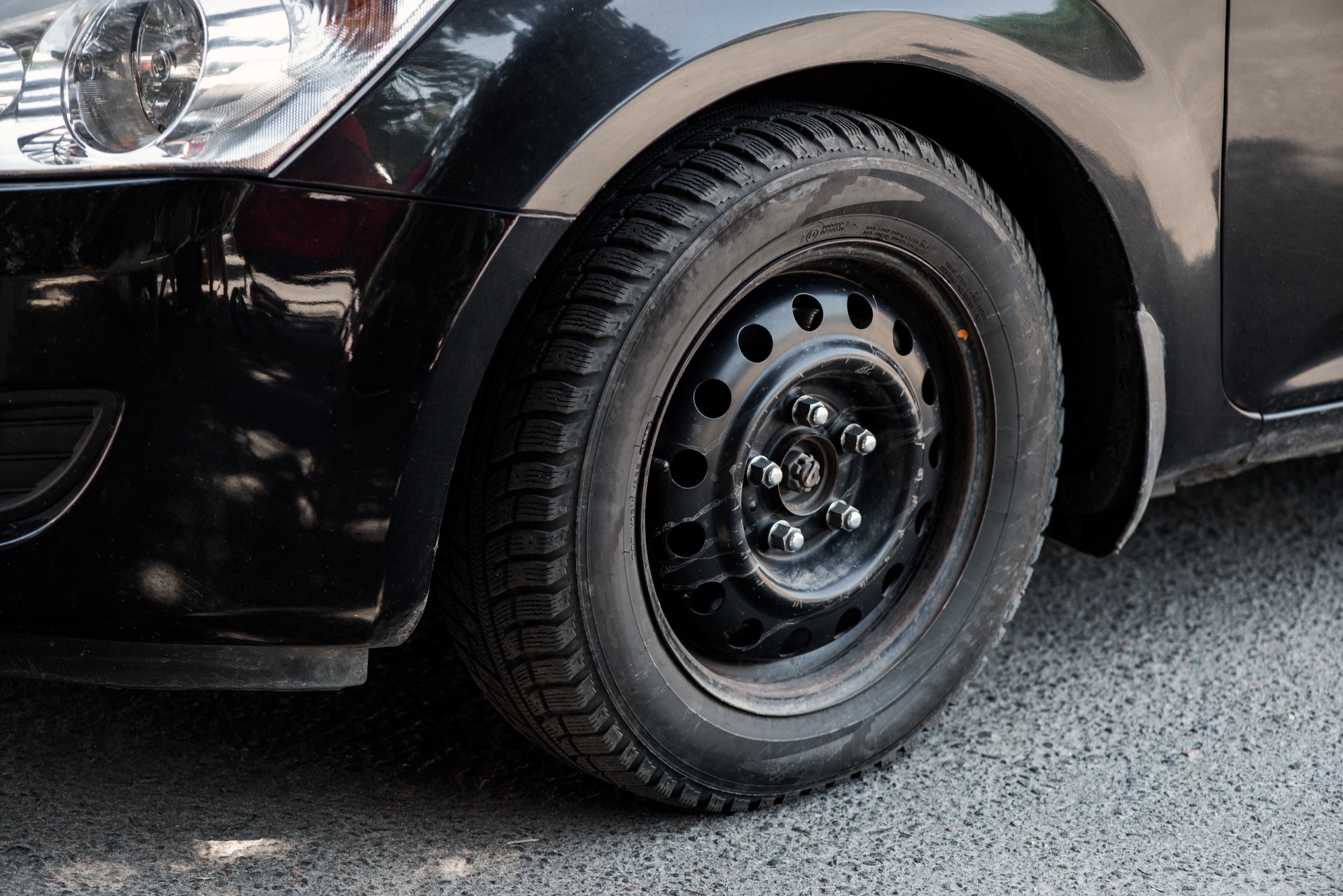 The image in front of the black car's wheel