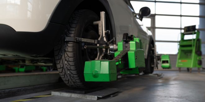 Wheel alignment of car wheels at car repair