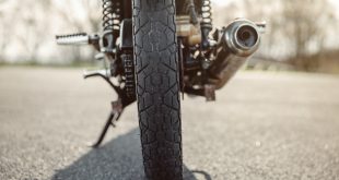 Wheel and exhaust pipe of motorcycle on road