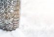 Winter tyre. Car tires on winter road covered with snow.