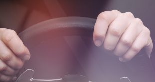 Woman's hands on steering wheel of a car