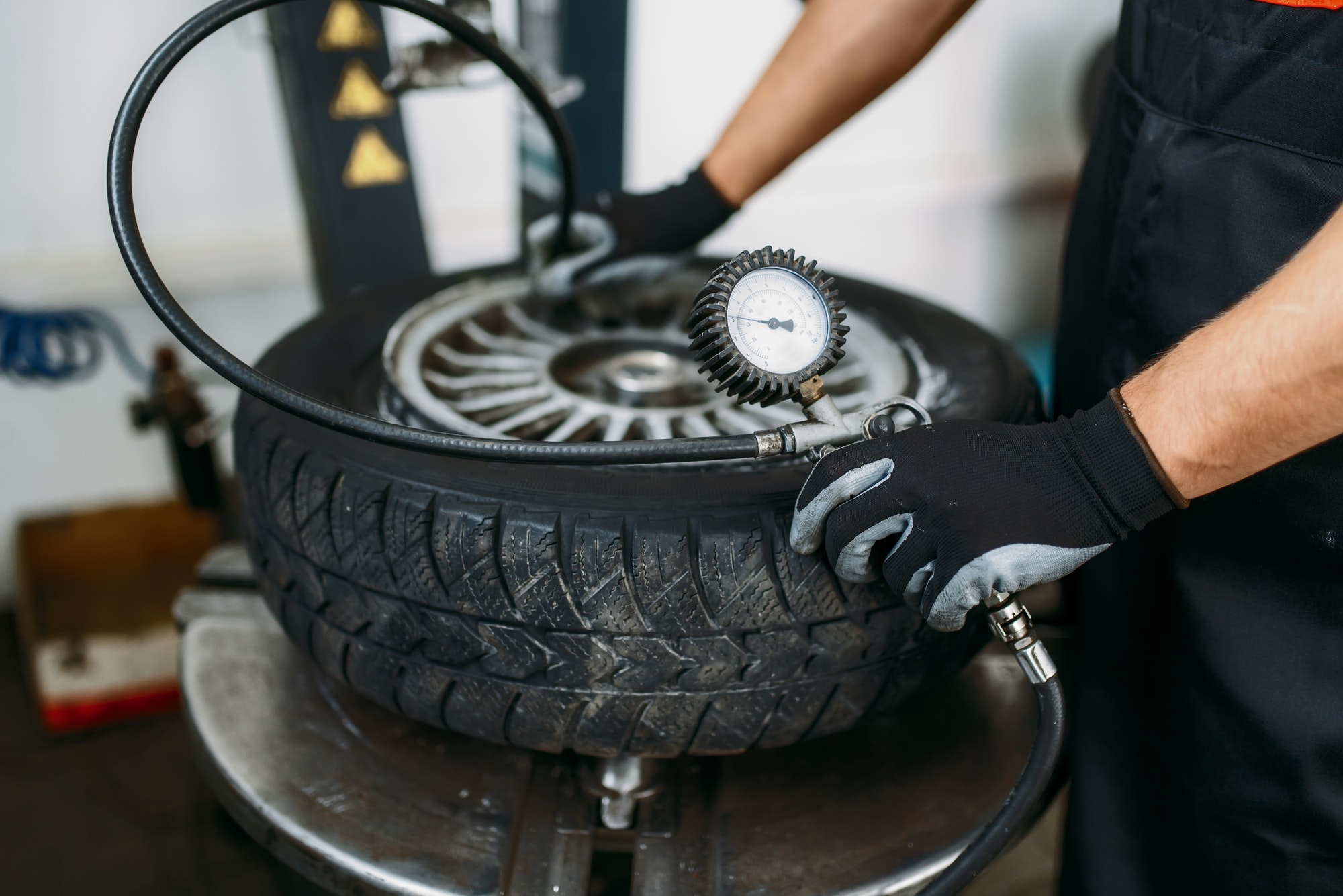 Mechanic inflates wheel, tire repairing service