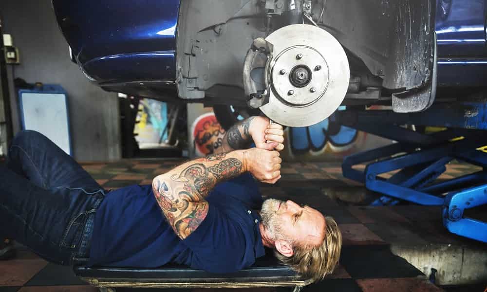Mecánico tumbado repara un freno