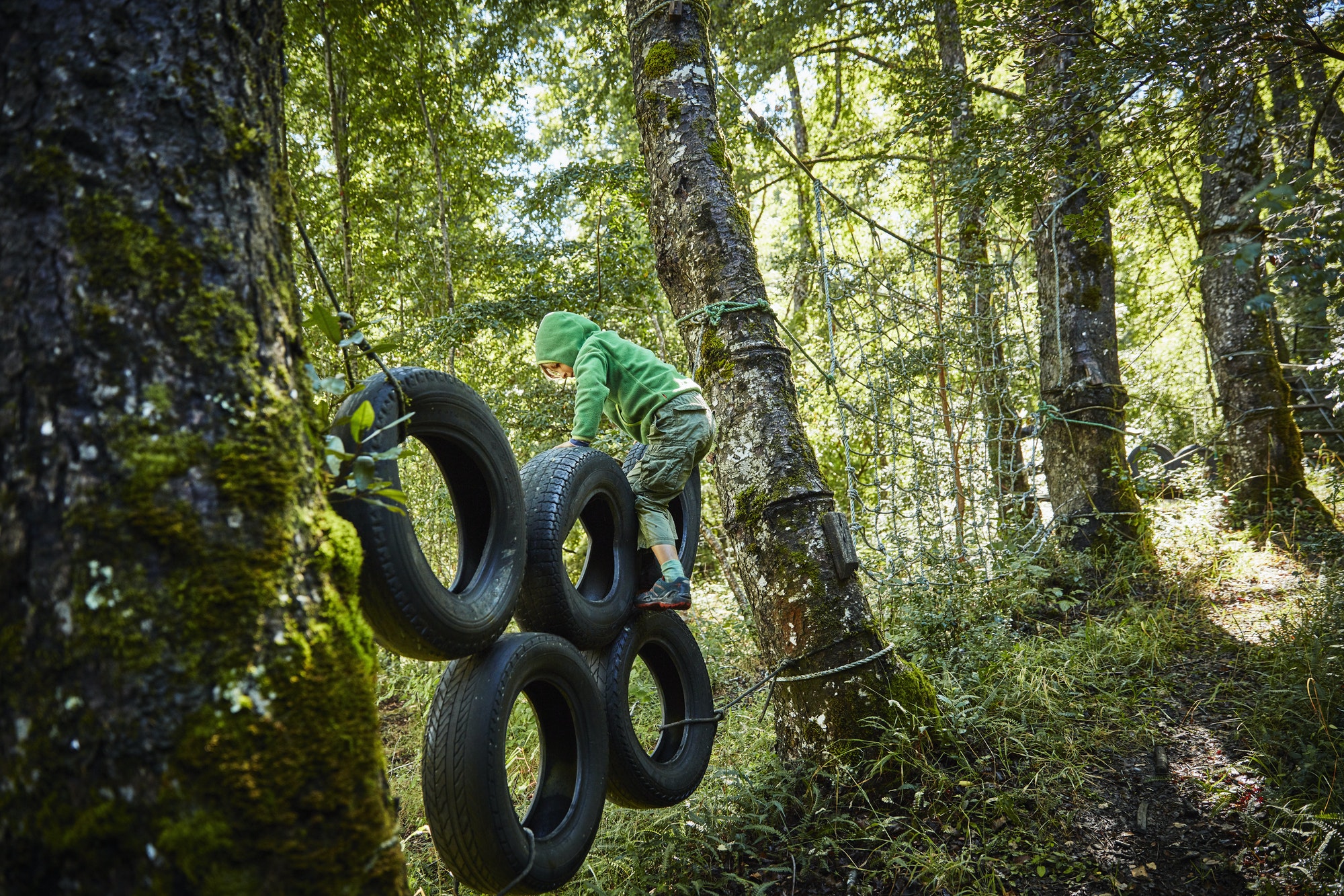Niño juega con neumáticos en la foresta de Sherwood