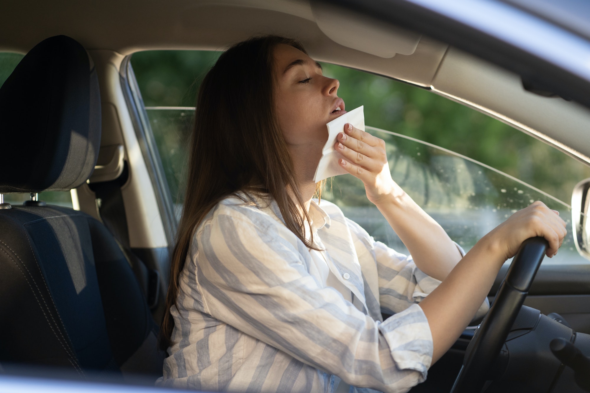 Mujer se refresca con un paño húmedo en el coche