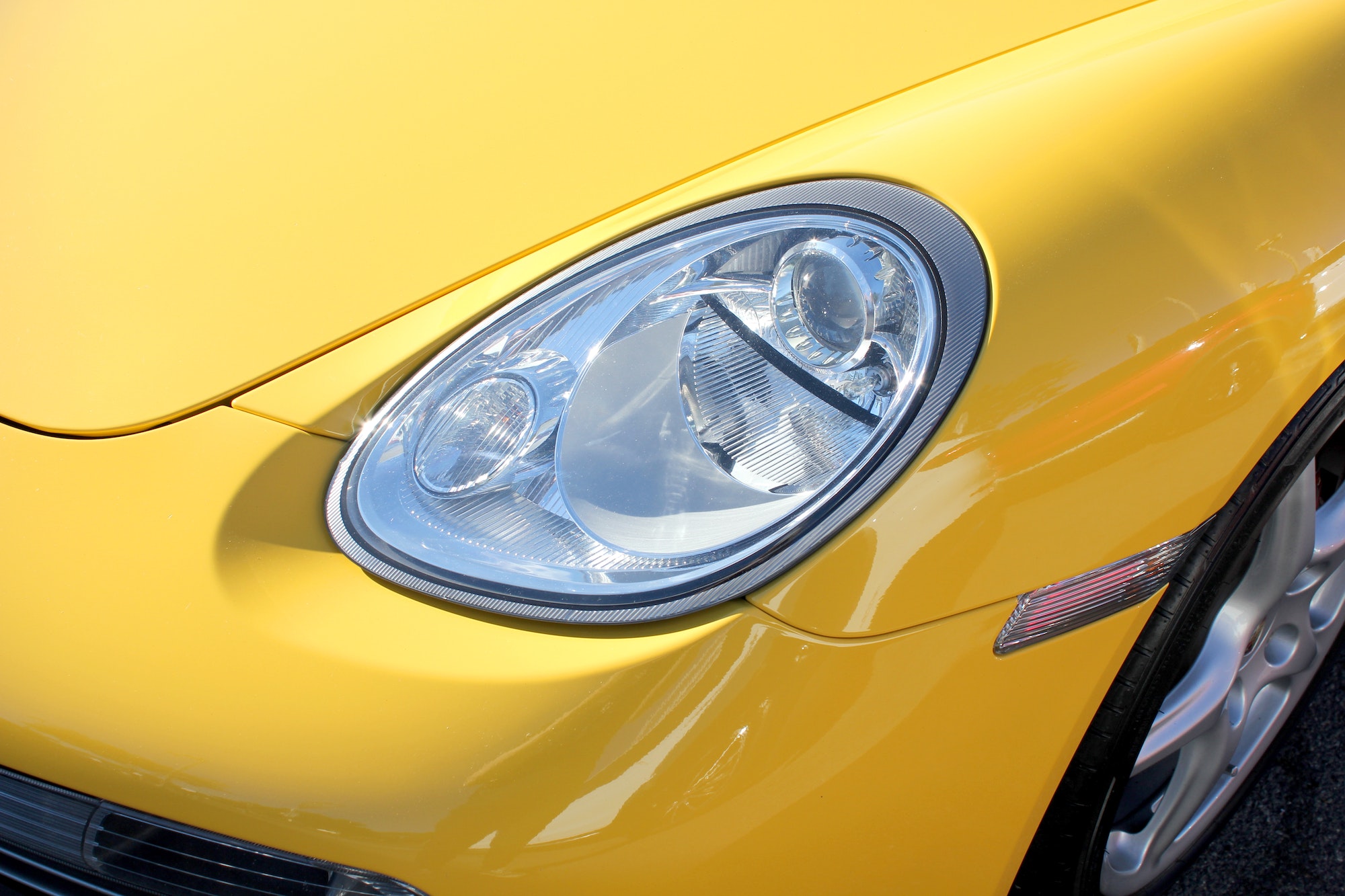 La luz delantera de un Porsche amarillo