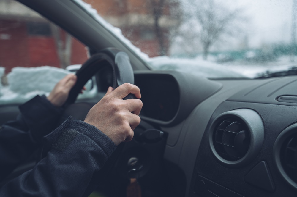 hombre conduciendo coche en invierno