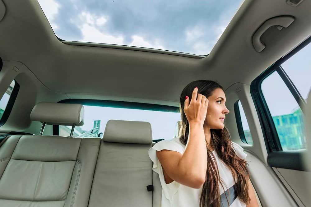 chica debajo de techo solar coche