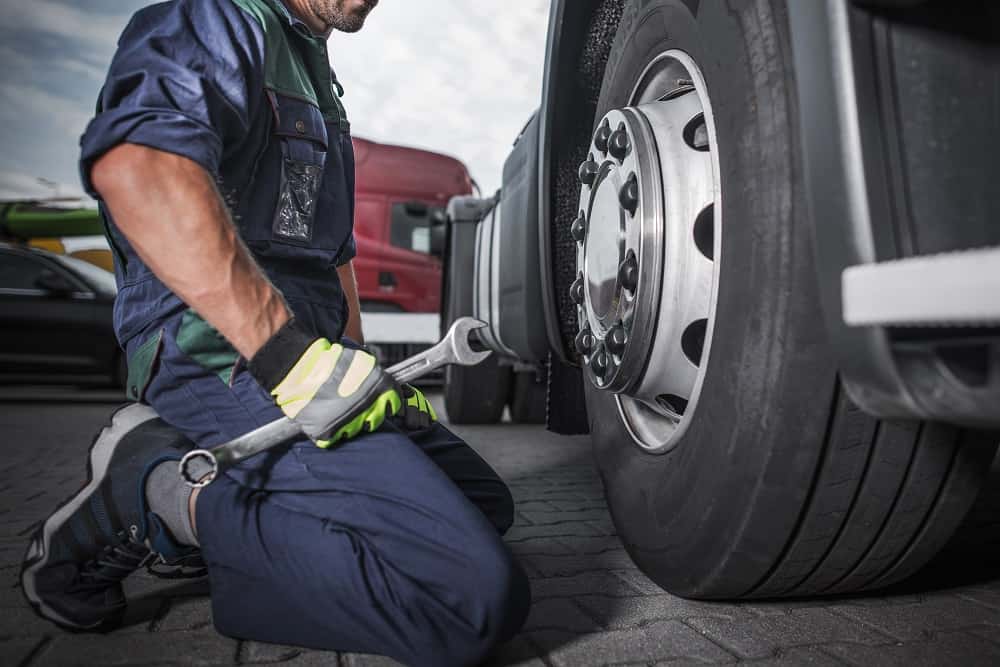 mecanico revisa un Neumático de camión