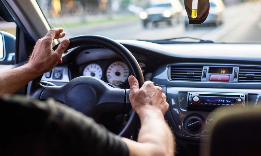 A man driving a car with cigarette