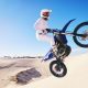 Jump, moto cross and man on motorcycle on sand for adrenaline, adventure and freedom in desert. Act