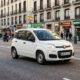 Imagen editorial de varios neumáticos 155/70 R13 montados en un coche urbano aparcado en una calle de España, representando una comparativa real de marcas y modelos en 2026.